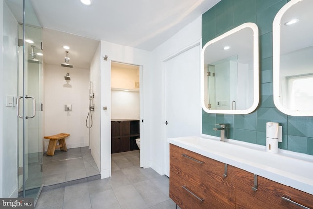 bathroom featuring decorative backsplash, vanity, toilet, and an enclosed shower