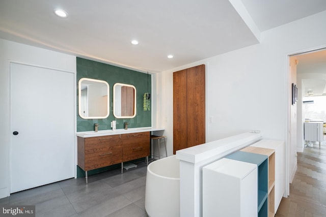 bathroom with a tub to relax in and vanity