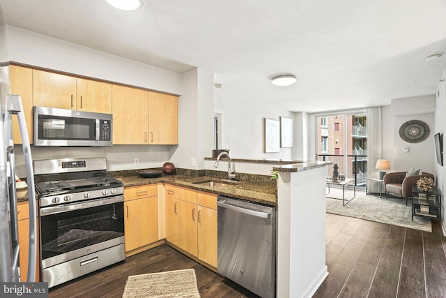 kitchen featuring sink, light brown cabinets, stainless steel appliances, dark hardwood / wood-style floors, and dark stone counters