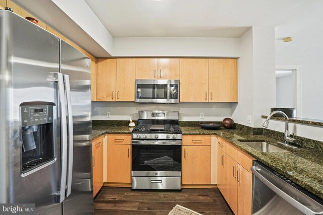 kitchen featuring dark stone countertops, sink, light brown cabinets, and appliances with stainless steel finishes