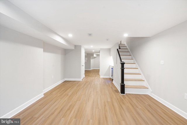 basement with light hardwood / wood-style floors