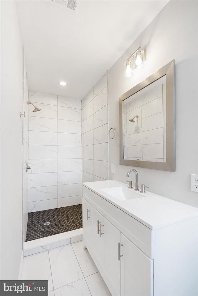 bathroom featuring vanity and tiled shower