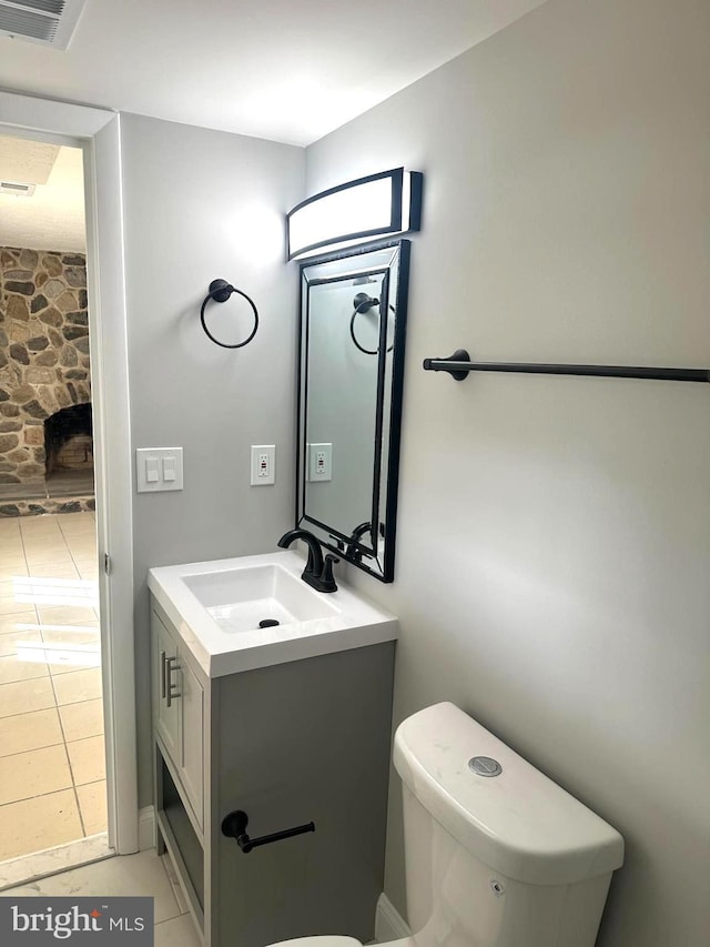 bathroom with toilet, tile patterned flooring, and vanity