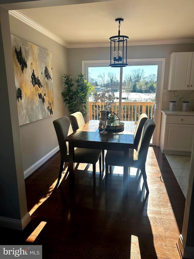 dining space featuring wood-type flooring, an inviting chandelier, and ornamental molding