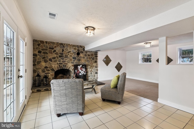 interior space with light colored carpet, a wealth of natural light, and a textured ceiling