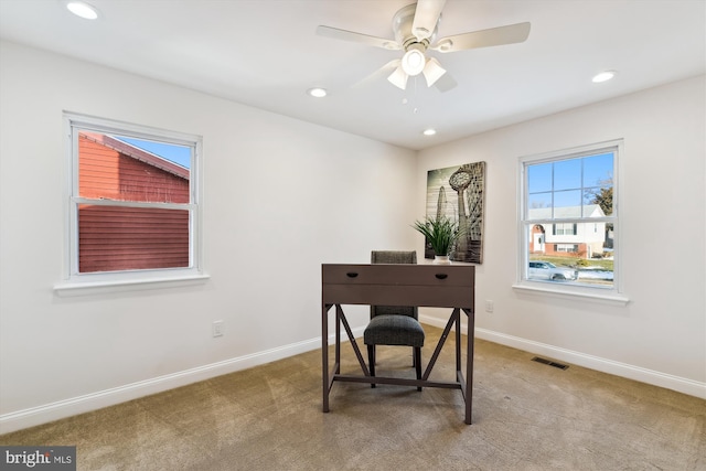 carpeted office with ceiling fan and a healthy amount of sunlight