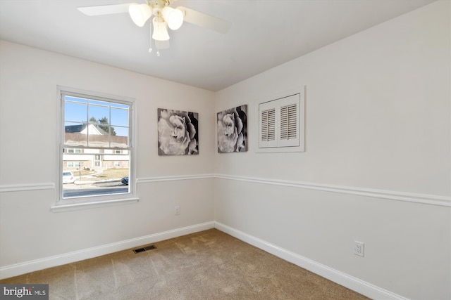 carpeted spare room with ceiling fan