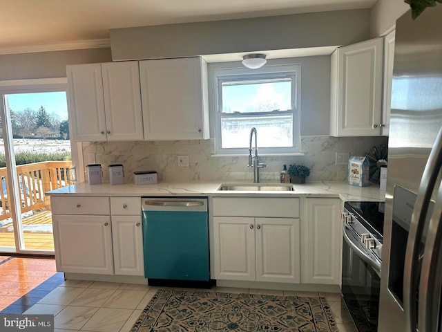 kitchen featuring white cabinets, appliances with stainless steel finishes, tasteful backsplash, sink, and light tile patterned floors