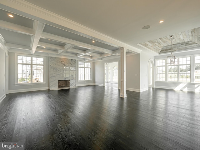 unfurnished living room with a high end fireplace, plenty of natural light, and dark wood-type flooring