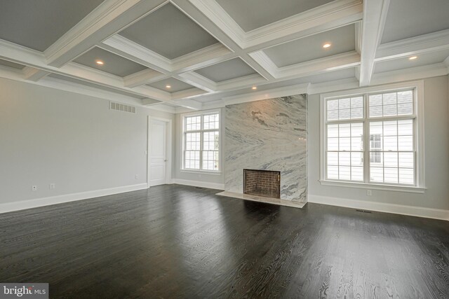 unfurnished living room featuring beamed ceiling, dark hardwood / wood-style flooring, a premium fireplace, and coffered ceiling