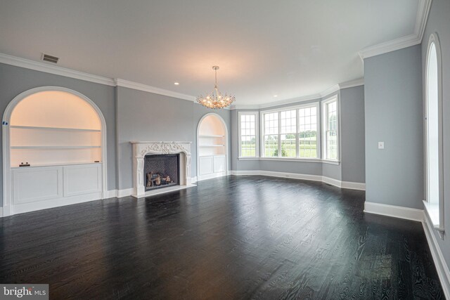 unfurnished living room with a high end fireplace, ornamental molding, dark wood-type flooring, built in features, and a chandelier