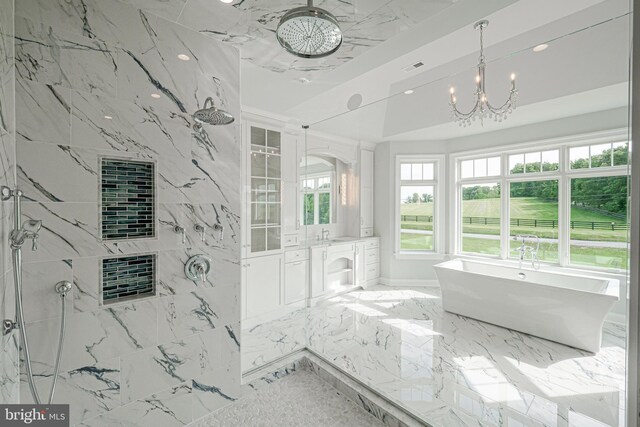 bathroom featuring a notable chandelier, plus walk in shower, and vanity