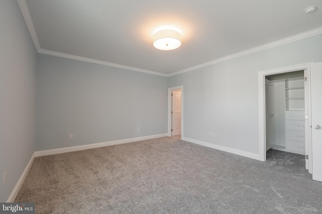 unfurnished bedroom with carpet, a walk in closet, a closet, and crown molding