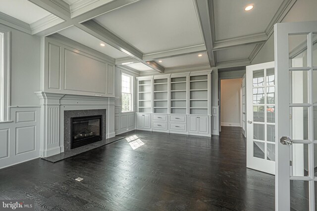 unfurnished living room featuring french doors, coffered ceiling, built in shelves, beamed ceiling, and a fireplace