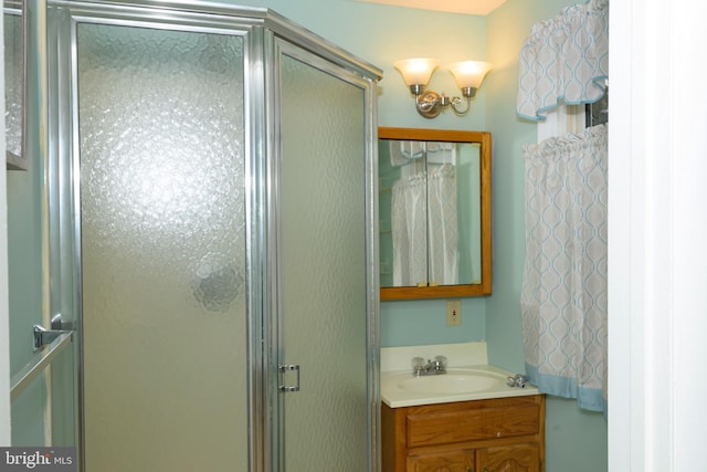 bathroom with vanity and a shower with door