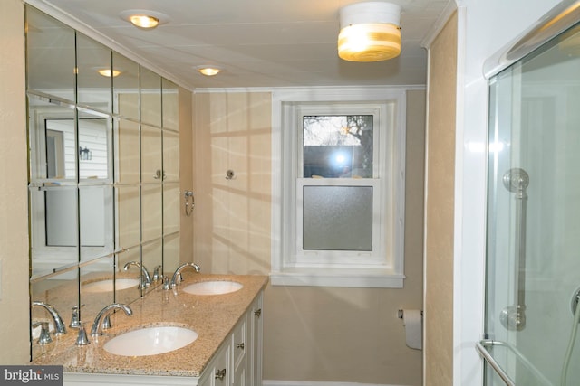 bathroom with vanity, an enclosed shower, and ornamental molding