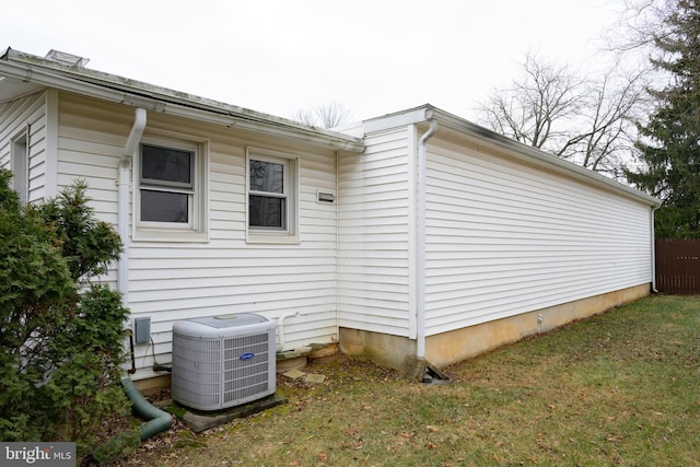 view of side of home featuring a yard and cooling unit