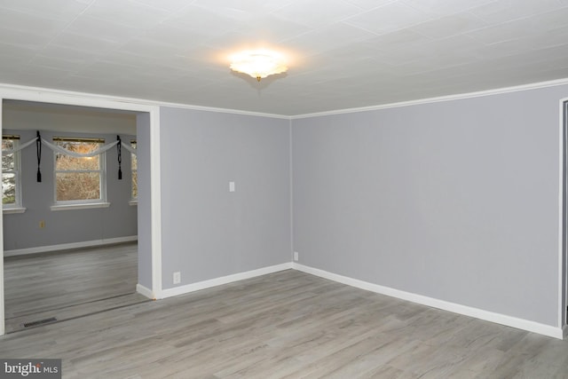 empty room with hardwood / wood-style flooring and ornamental molding