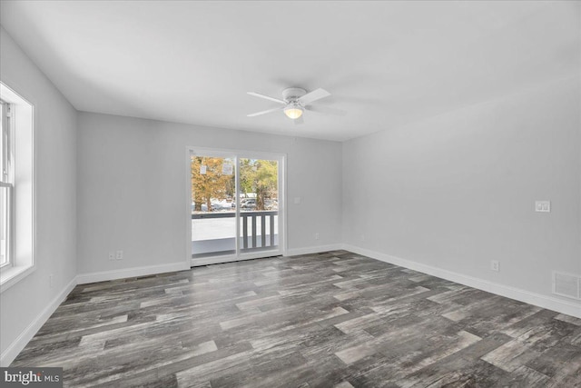 spare room with ceiling fan, a healthy amount of sunlight, and dark hardwood / wood-style floors