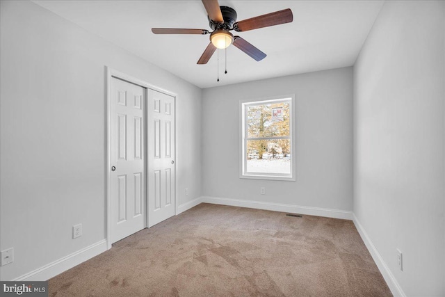 unfurnished bedroom with carpet flooring, ceiling fan, and a closet