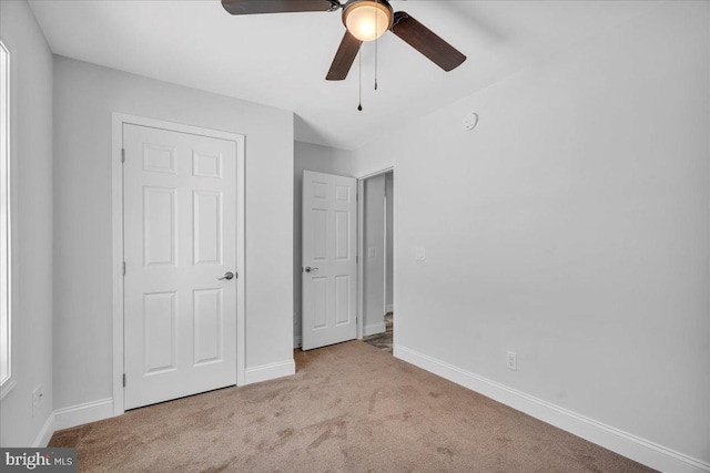 unfurnished bedroom featuring ceiling fan and light carpet