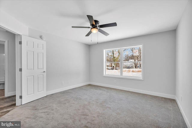 carpeted spare room with ceiling fan