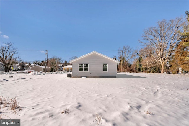 view of snow covered back of property