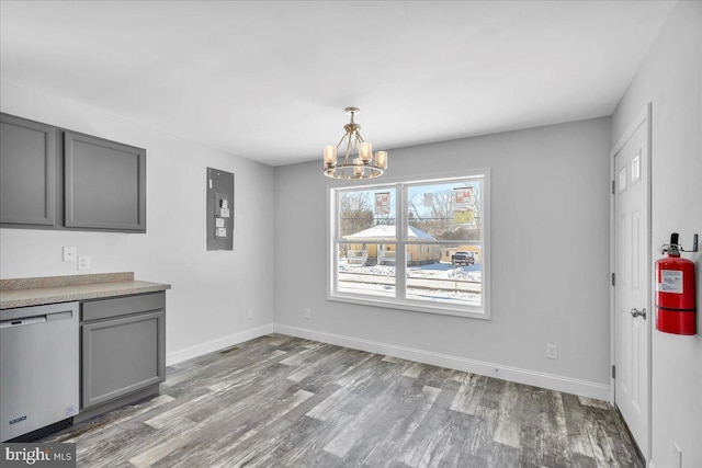 unfurnished dining area with light hardwood / wood-style floors, electric panel, and an inviting chandelier