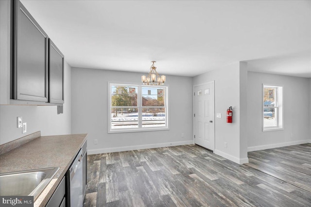 unfurnished dining area with a notable chandelier, light wood-type flooring, and sink