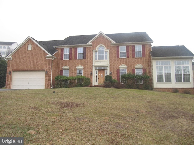 colonial home featuring a front yard and a garage