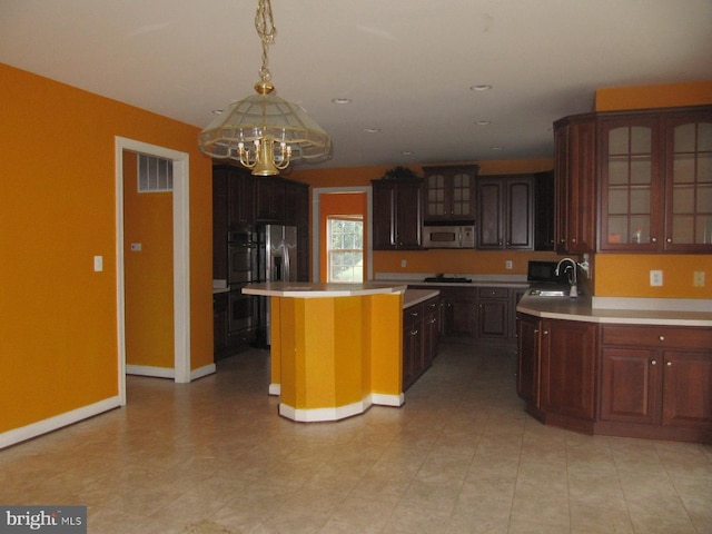 kitchen with a center island, oven, sink, dark brown cabinets, and gas cooktop