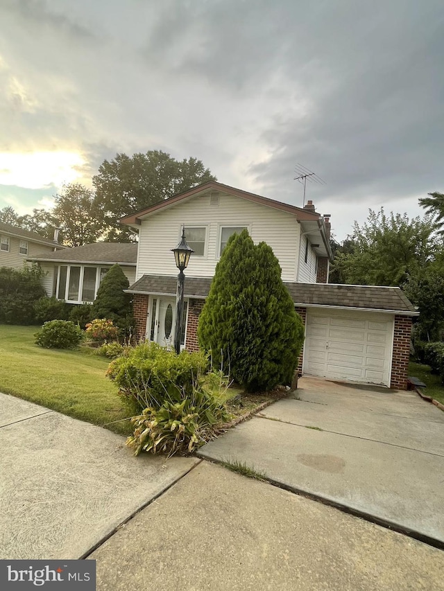 view of side of home featuring a lawn and a garage