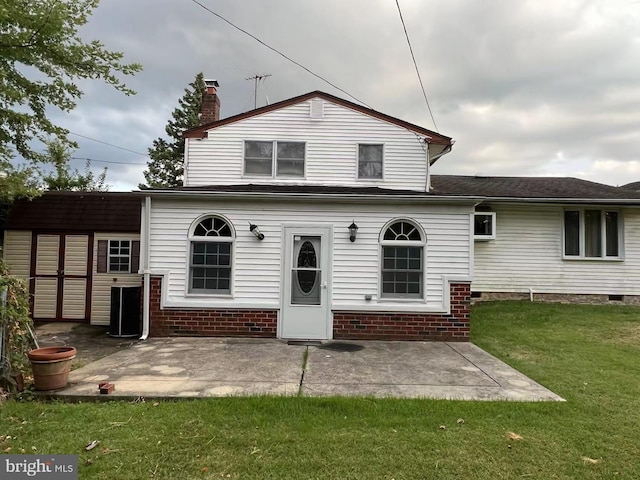 rear view of property featuring a lawn and a patio