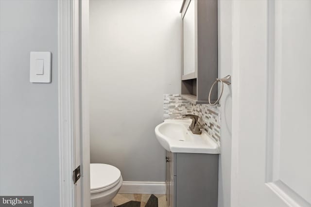 bathroom with tasteful backsplash, vanity, and toilet