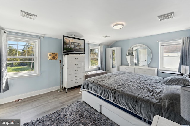 bedroom featuring hardwood / wood-style flooring and vaulted ceiling