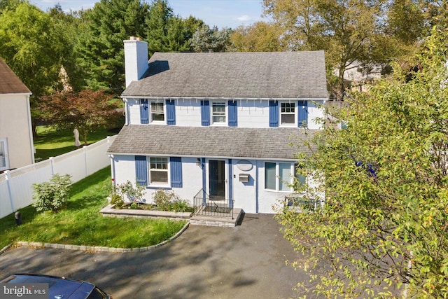 colonial inspired home featuring a front lawn