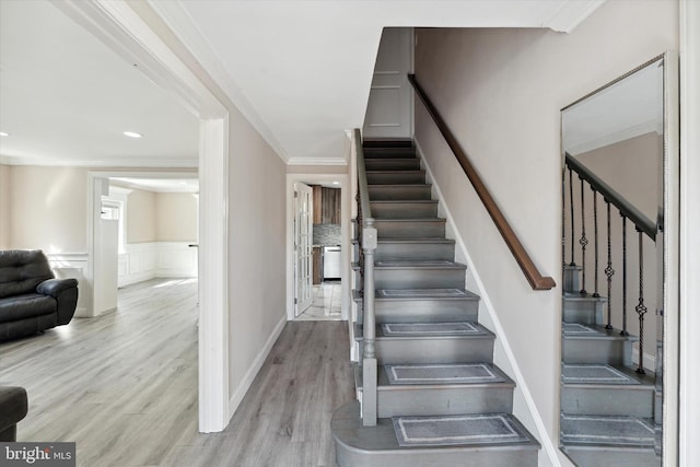 stairway with hardwood / wood-style flooring and ornamental molding