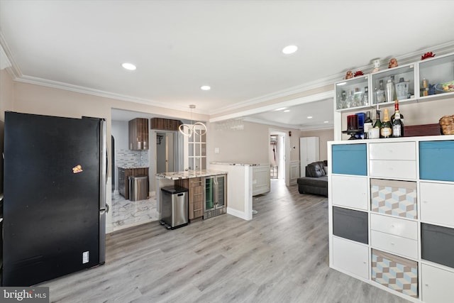 kitchen featuring stainless steel refrigerator, beverage cooler, light hardwood / wood-style flooring, crown molding, and pendant lighting