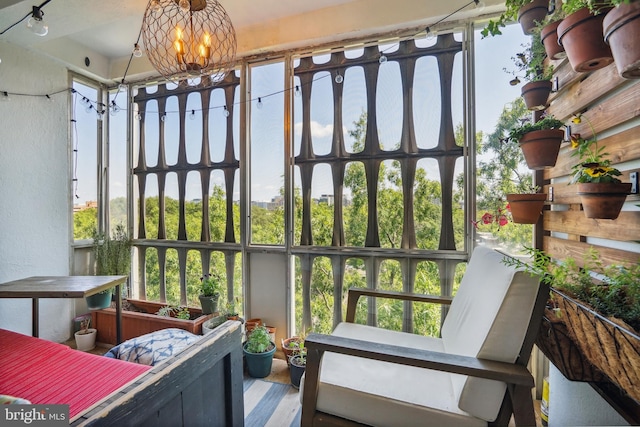 sunroom / solarium with a notable chandelier