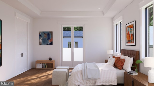 bedroom featuring crown molding, hardwood / wood-style floors, and a raised ceiling