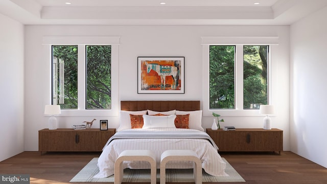 bedroom with ornamental molding, dark wood-type flooring, and a tray ceiling