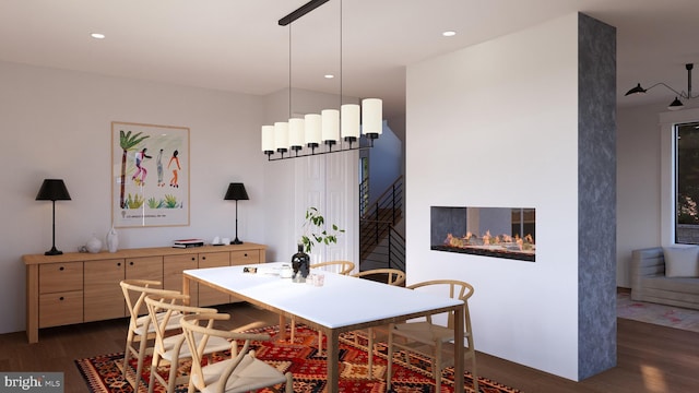 dining area with a large fireplace and dark hardwood / wood-style floors