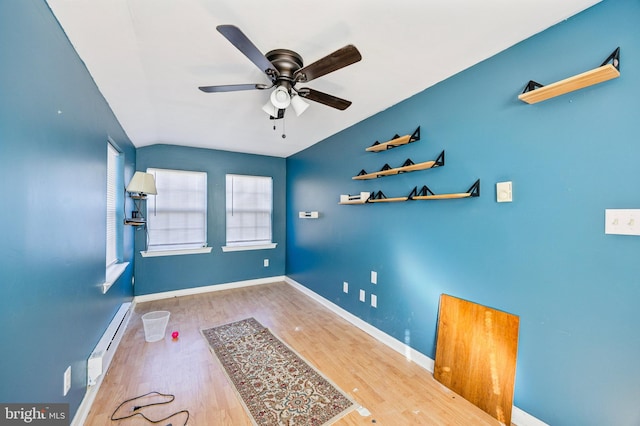 interior space featuring ceiling fan, a healthy amount of sunlight, wood-type flooring, and baseboard heating