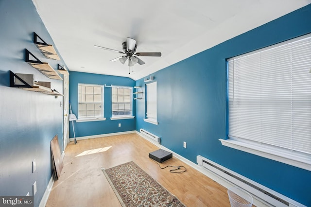 interior space with baseboard heating, ceiling fan, and light hardwood / wood-style flooring