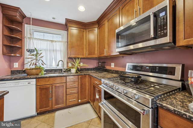 kitchen featuring light tile patterned flooring, sink, stainless steel appliances, and dark stone counters