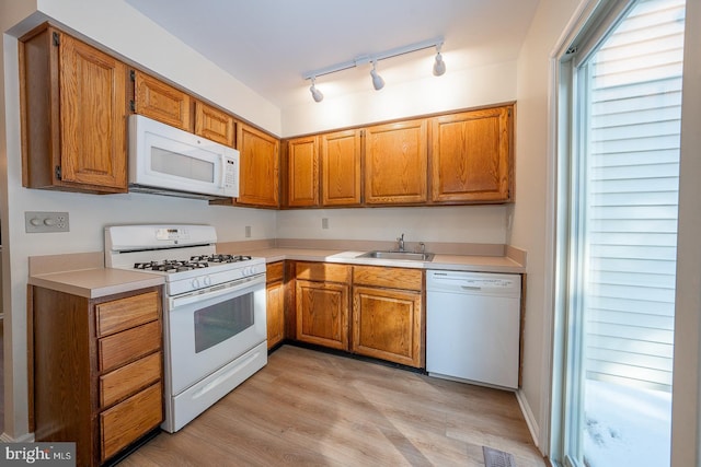 kitchen with sink, white appliances, and light wood-type flooring