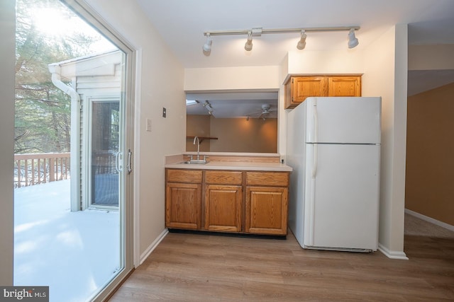 kitchen featuring sink, light hardwood / wood-style flooring, and white fridge