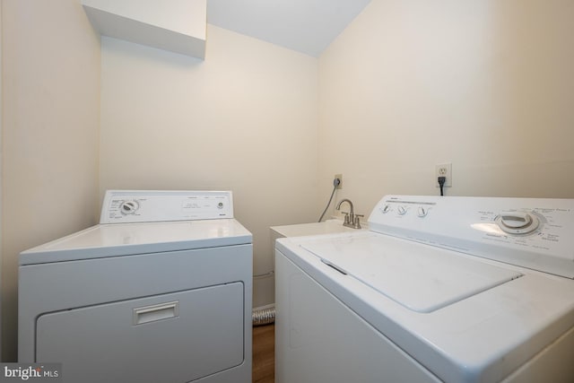 laundry area featuring sink, dark hardwood / wood-style floors, and washer and clothes dryer