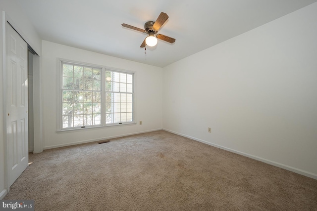 unfurnished room with carpet flooring and ceiling fan