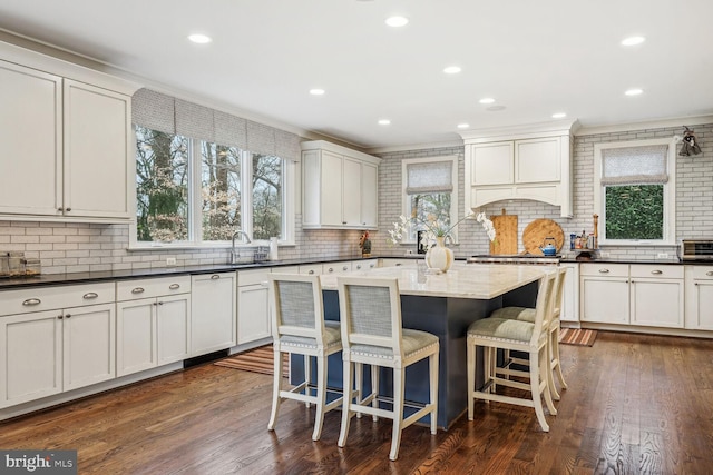 kitchen featuring backsplash, dark hardwood / wood-style flooring, and a center island